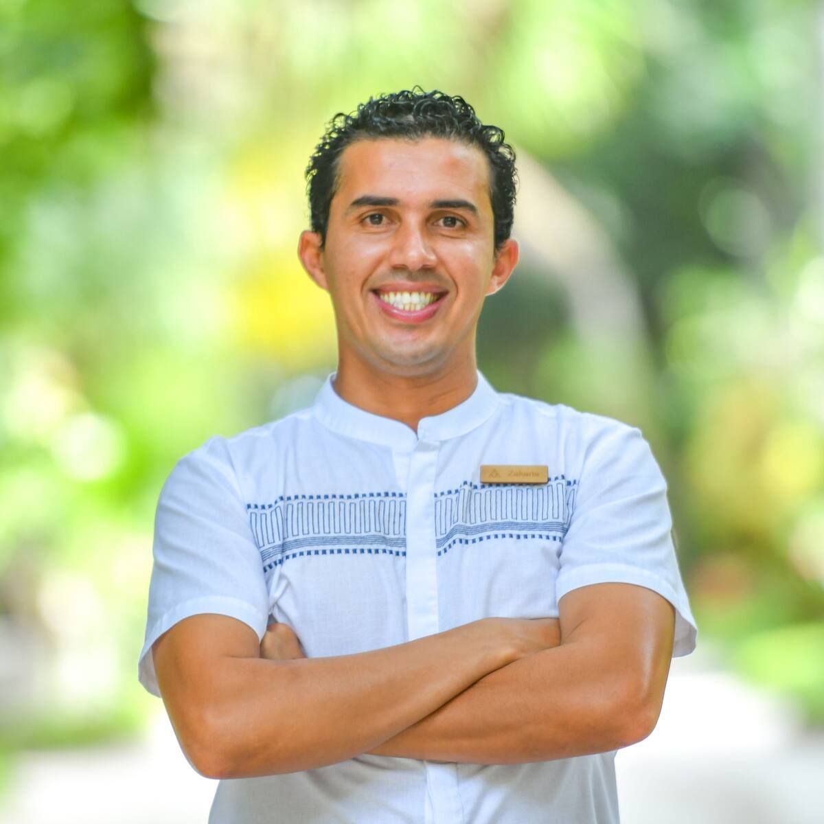 Zakaria, the host, smiling, arms crossed